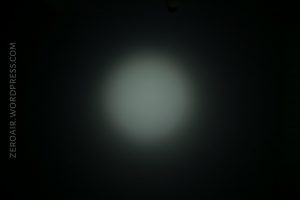 A circular beam of white light with soft edges shines on a dark background. The text “ZEROAIR.WORDPRESS.COM” appears vertically on the left side.