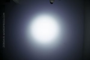 A circular white light shines on a dark surface, creating a gradient from bright white in the center to dark gray at the edges. The text ZEROAIR.WORDPRESS.COM appears vertically along the left edge.
