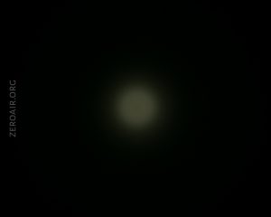 A faint circular light appears in the center of a dark background. The text ZEROAIR.ORG is vertically aligned along the left edge of the image.