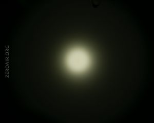A circular white light is shown in the center of a dark background, creating a halo effect. The text ZEROAIR.ORG is visible vertically on the left side of the image.