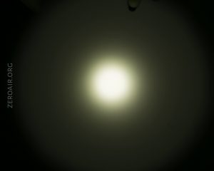 A circular, bright white light source is centered against a dark background, creating a gradient halo effect. The text ZEROAIR.ORG is visible on the left side of the image.