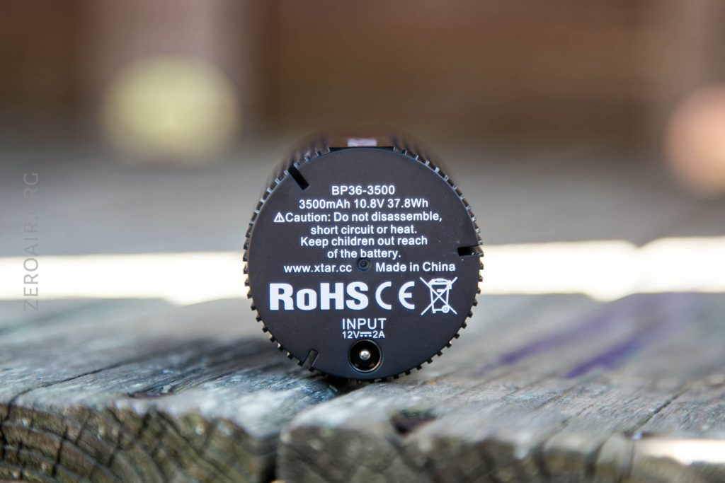 A close-up of the bottom of a cylindrical battery labeled BP36-3500, 3500mAh 10.8V 37.8Wh, showing technical information, caution warnings, certification marks, and Made in China text.