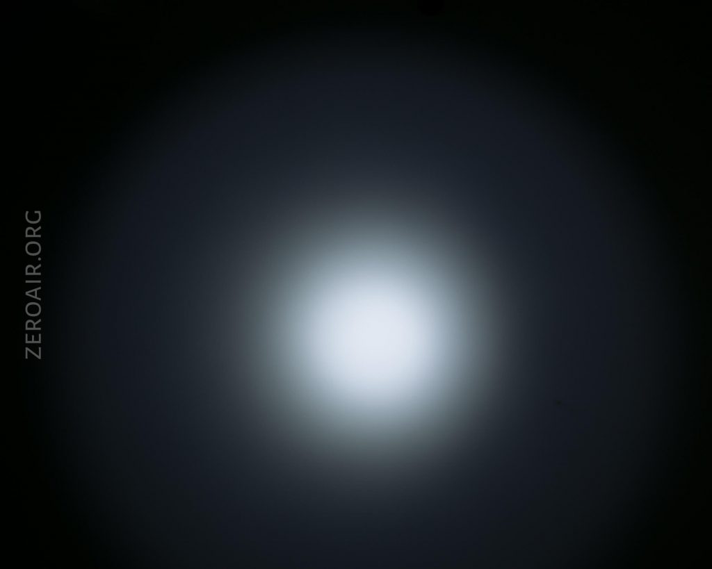 A centered white light with a soft glow fades into a dark background. The words ZEROAIR.ORG appear vertically along the left side.