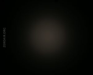 A dark image with a faint, circular light spot in the center, surrounded by black. The text ZEROAIR.ORG is vertically aligned on the left side.