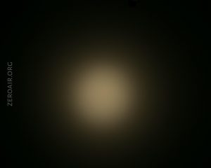 A circular, dim beam of light appears in the center of a dark background. The text ZEROAIR.ORG is vertically aligned on the left side of the image.