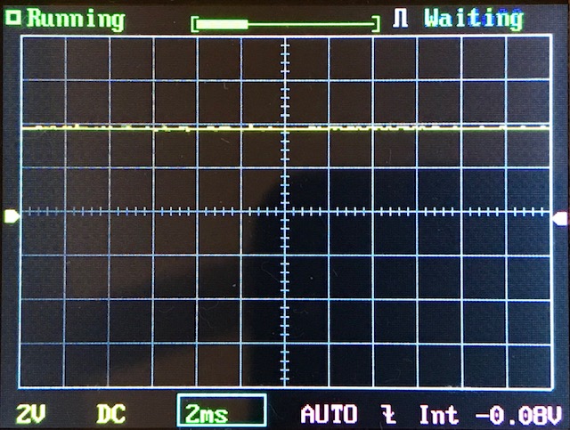 An oscilloscope screen displays a mostly flat horizontal yellow signal trace. The settings at the bottom show 2V/div and 2ms/div with AUTO trigger mode. Status indicators read Running and Waiting at the top.