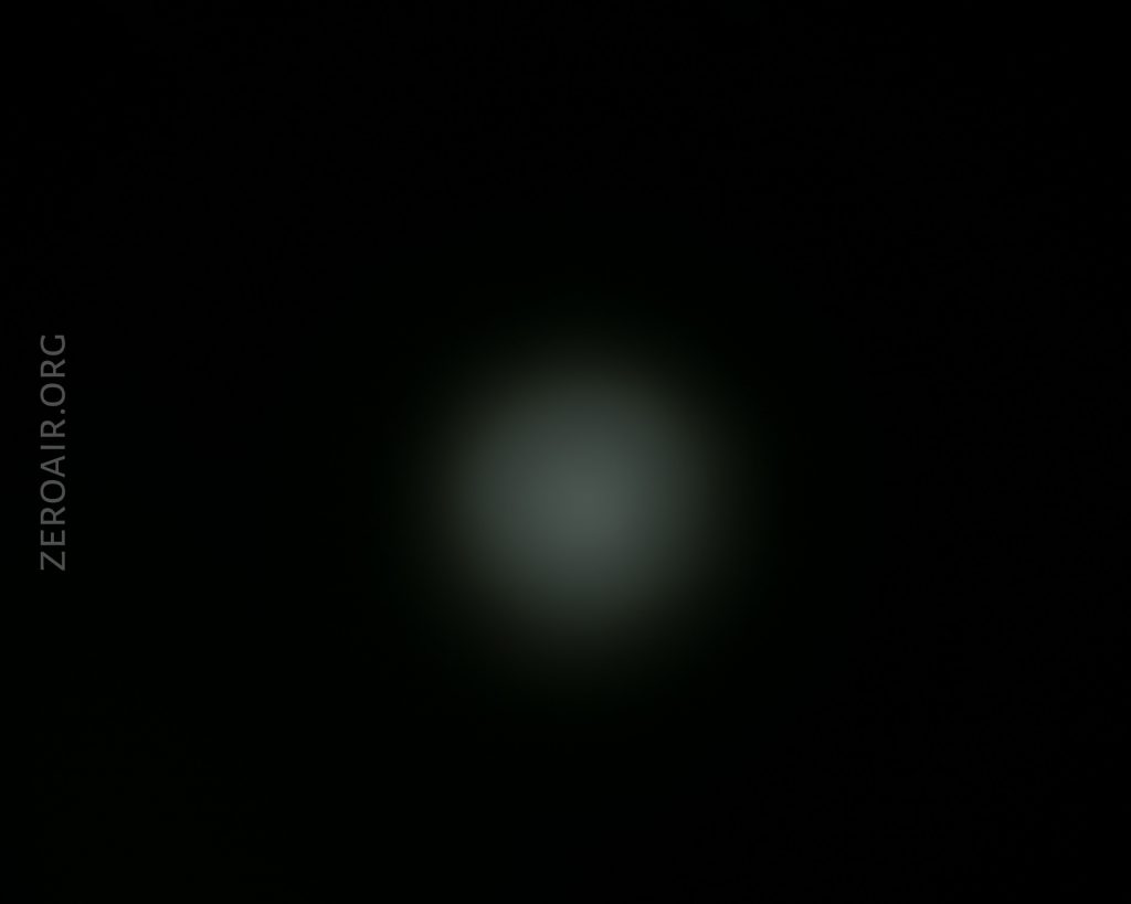 A faint, circular white light appears in the center of a dark background. The text “ZEROAIR.ORG” is vertically aligned on the left side of the image.