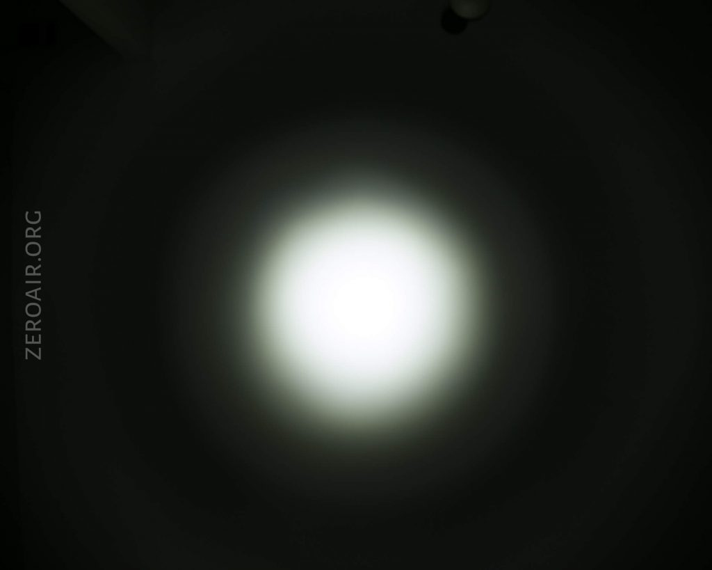 A bright, circular white light is centered against a dark background, creating a gradient halo effect. The text ZEROAIR.ORG is vertically visible on the left side of the image.