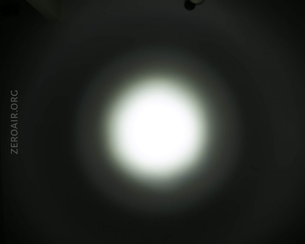 A bright white circular light with a soft gradient appears in the center of a dark background. The website text ZEROAIR.ORG is visible on the left side of the image.