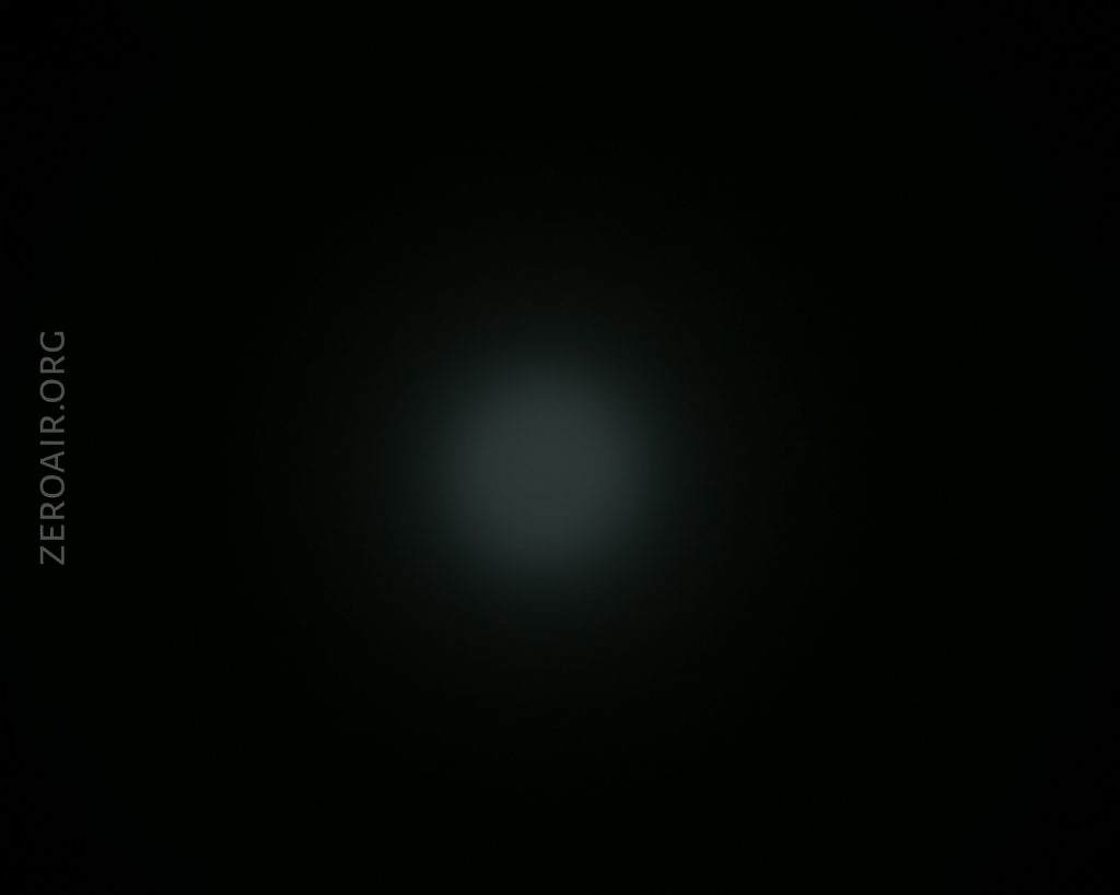 A dim, circular white light appears in the center of a dark background. The text ZEROAIR.ORG is visible vertically on the left side of the image.