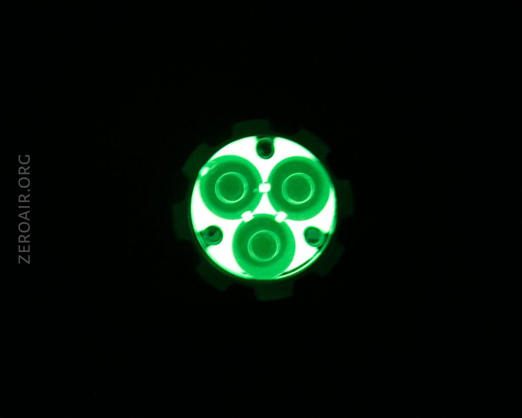 A circular object with four green glowing concentric circles is centered on a black background. The text “ZEROAIR.ORG” is vertically aligned on the left side of the image.
