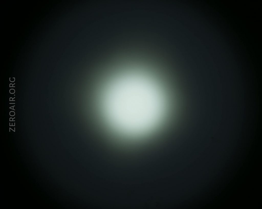 A bright white circular light is centered against a dark background, creating a glowing halo effect. The text ZEROAIR.ORG appears vertically along the left side.