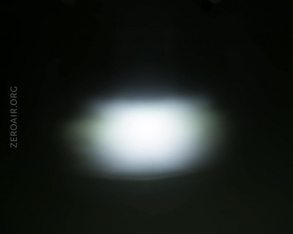 A bright white light source is shining in the center of a dark background, creating a soft, blurred glow. The text ZEROAIR.ORG is visible along the left side of the image.