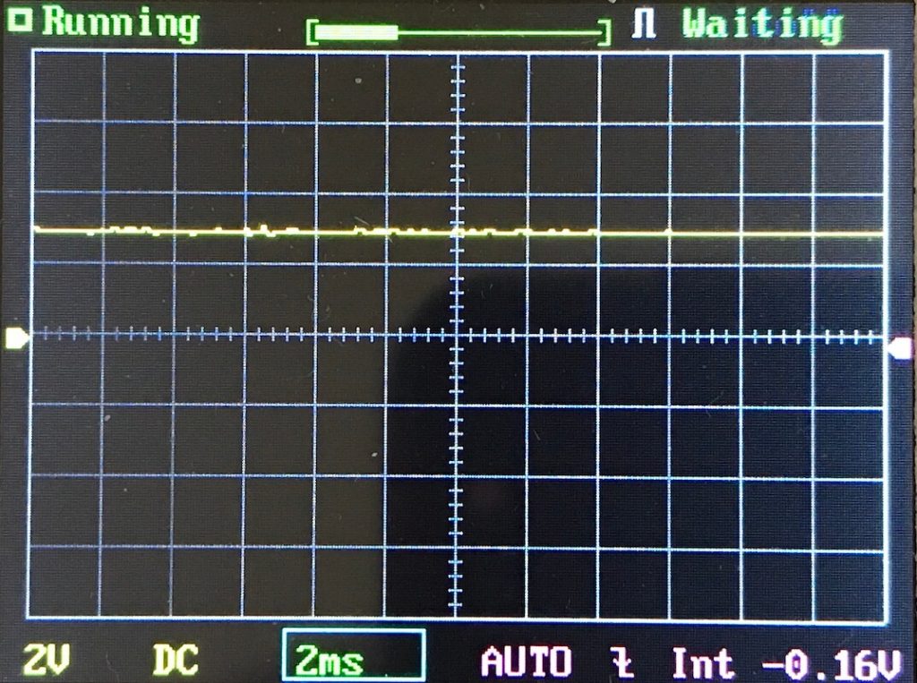 A digital oscilloscope screen shows a mostly flat yellow trace near the center, vertical and horizontal grid lines, and indicators for running, waiting, 2V, DC, 2ms, AUTO, and -0.16V.
