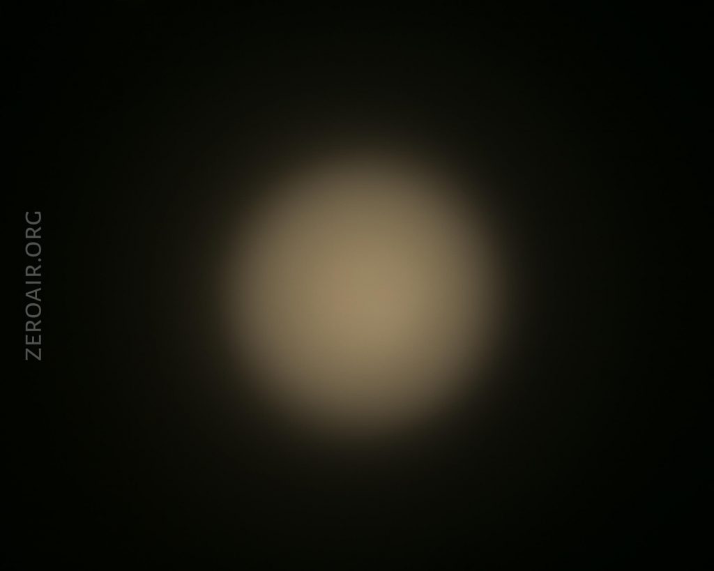 A blurred, circular white light is centered against a dark background. The text ZEROAIR.ORG appears vertically on the left side of the image.