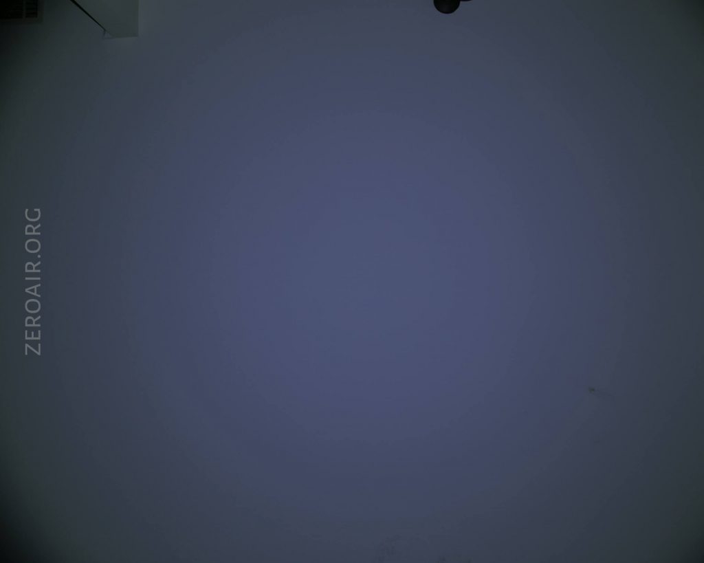 A dark, mostly featureless surface with a gradient ranging from dark blue to black. The text ZEROAIR.ORG appears vertically on the left side. A small dark object is partially visible at the top edge.