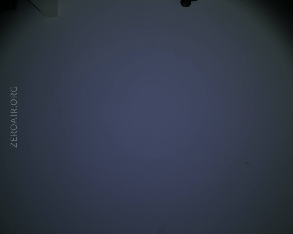 A dark, mostly plain background with a faint gradient. ZEROAIR.ORG is written vertically along the left edge. A small, unidentifiable dark object is partially visible at the top right corner.