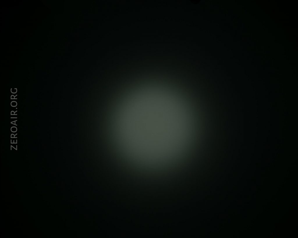 A dim, circular beam of light appears in the center of a dark background. The text “ZEROAIR.ORG” is written vertically on the left side of the image.