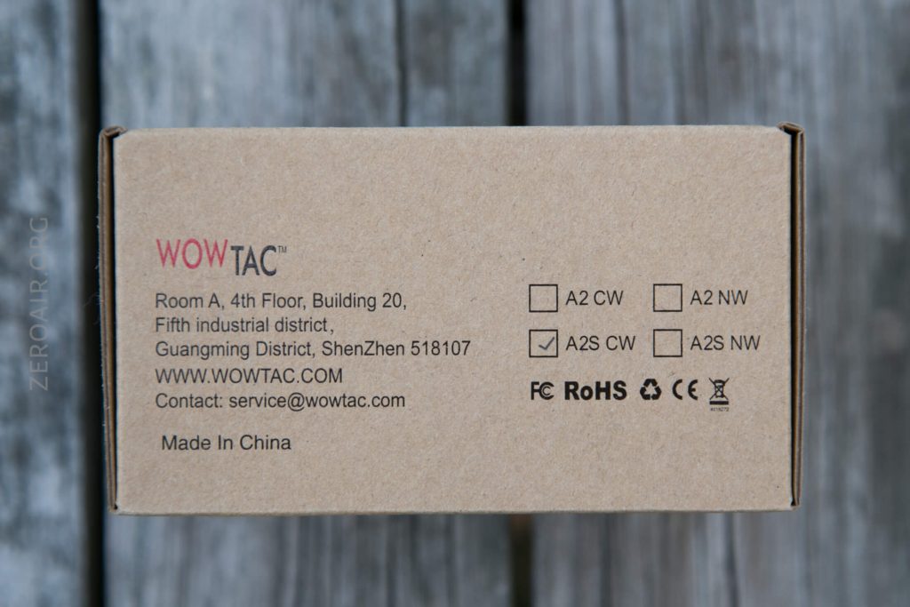 A cardboard product box from WOWTAC, showing the company address in Shenzhen, China, contact info, website, and checkboxes for model types. The A2S CW box is checked. Various certification logos are visible.