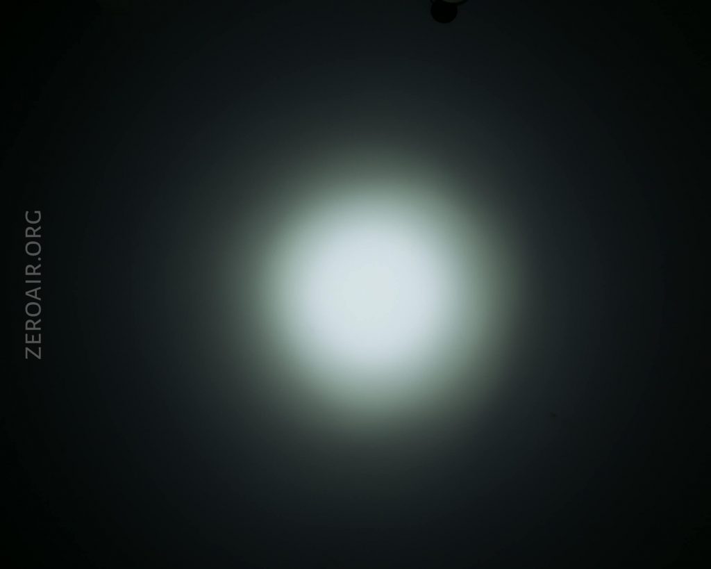A bright white circular light is centered against a dark background, gradually fading to black at the edges. The text ZEROAIR.ORG is vertically aligned on the left side of the image.