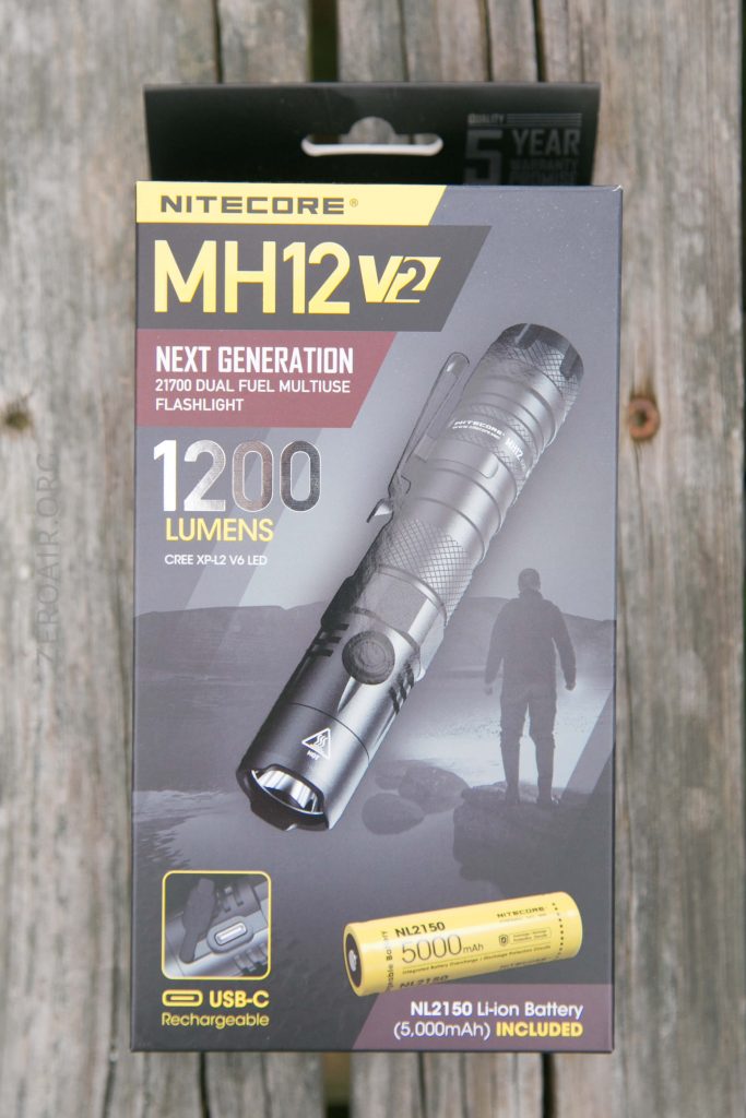 The image shows the packaging of a Nitecore MH12 v2 flashlight, featuring 1200 lumens, USB-C charging, and a 5000mAh rechargeable battery. The box also mentions a 5-year warranty and highlights next generation technology.