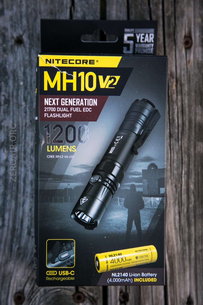 A box containing a Nitecore MH10 V2 flashlight is shown. The packaging highlights features such as 1200 lumens, 21700 dual fuel, USB-C charging, and includes a 4000mAh rechargeable battery.