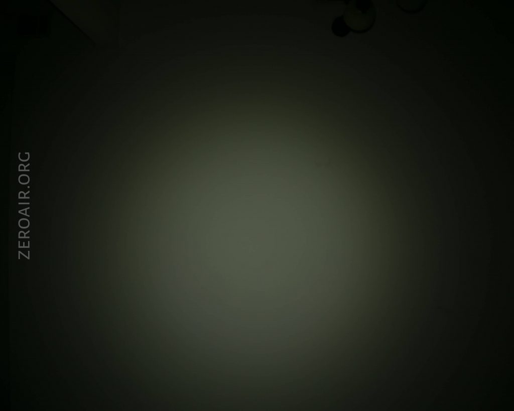 A dimly lit, circular patch of light appears on a dark background. The text ZEROAIR.ORG is faintly visible on the left side. The source of the light is not shown in the image.