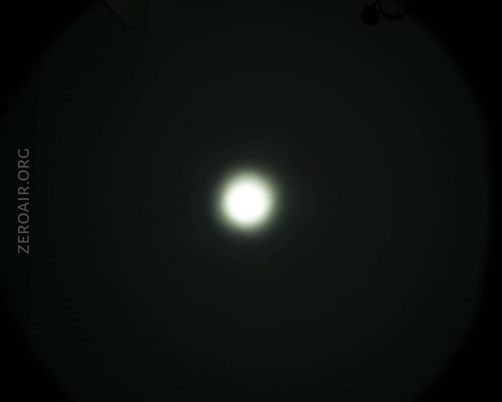 A bright white circular light is centered against a dark background, creating a halo effect. The text ZEROAIR.ORG is visible vertically along the left side of the image.