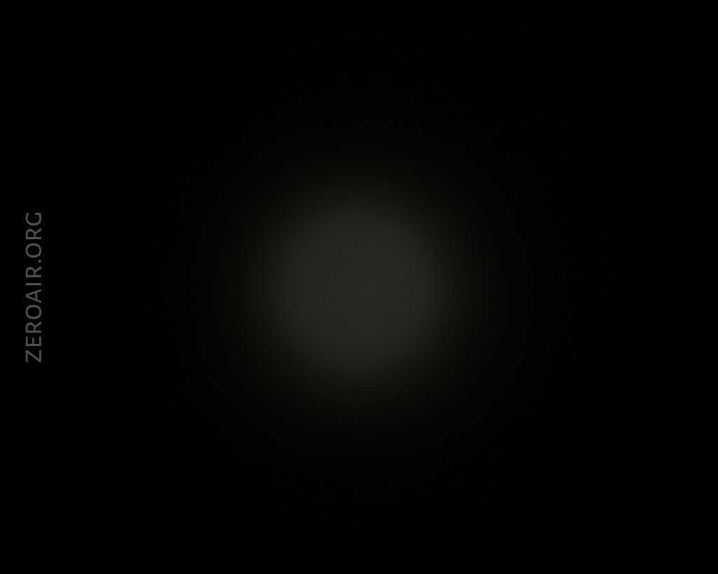 A dim, circular light appears in the center of a mostly dark background. The text ZEROAIR.ORG is faintly visible along the left side of the image in a vertical orientation.