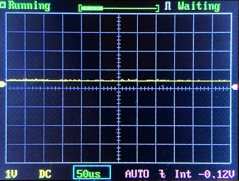 Oscilloscope screen displaying a flat horizontal yellow line near zero, grid lines, and indicators for 1V DC, 50 microseconds, AUTO mode, and -0.12V offset. Status shows Running and Waiting.