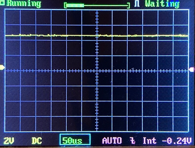 Oscilloscope screen showing a mostly flat yellow waveform near the top grid line, indicating minimal signal variation. The display shows settings: 2V/div, 50 microseconds/div, DC coupling, and AUTO trigger mode.