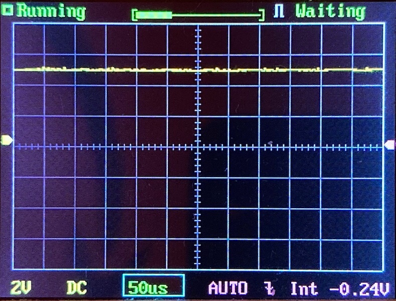 Digital oscilloscope display showing a mostly flat yellow waveform near the top of the screen, with status indicators reading Running and Waiting. Settings include 2V/div, 50µs/div, and AUTO trigger mode.