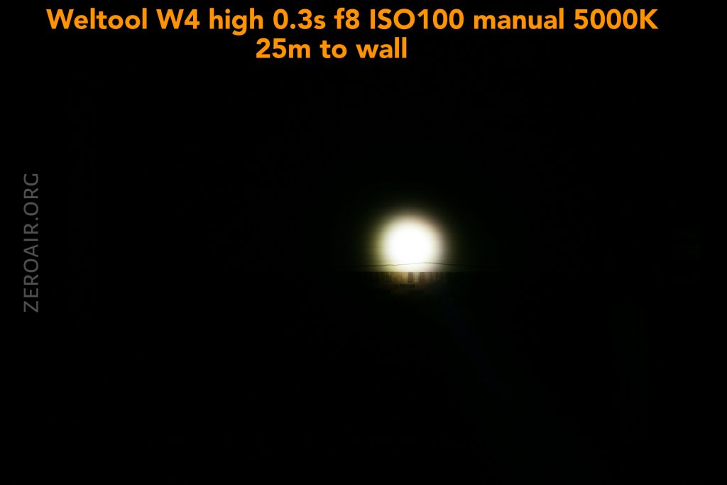 A bright circular light is visible in the center of a dark background. Orange text at the top reads, Weltool W4 high 0.3s f8 ISO100 manual 5000K 25m to wall. The words ZEROAIR.ORG appear vertically on the left side.