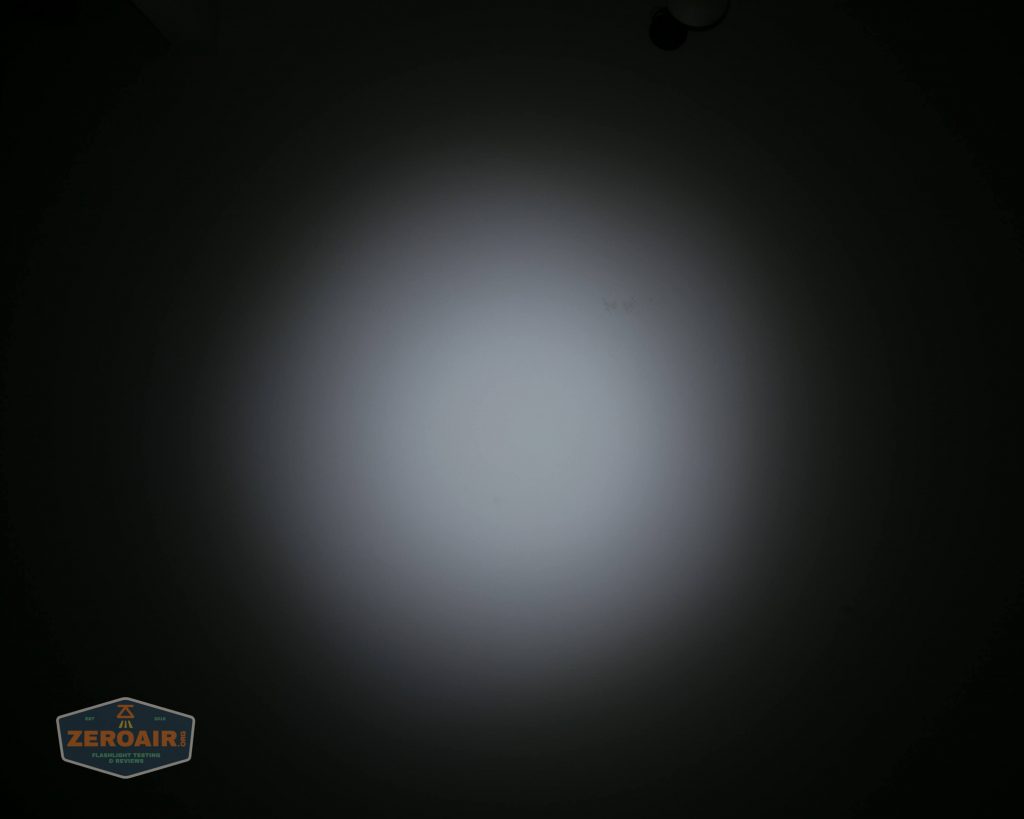 A circular white light beam is centered on a dark background, creating a gradient from bright white in the middle to black at the edges. A small ZeroAir logo appears in the bottom left corner.