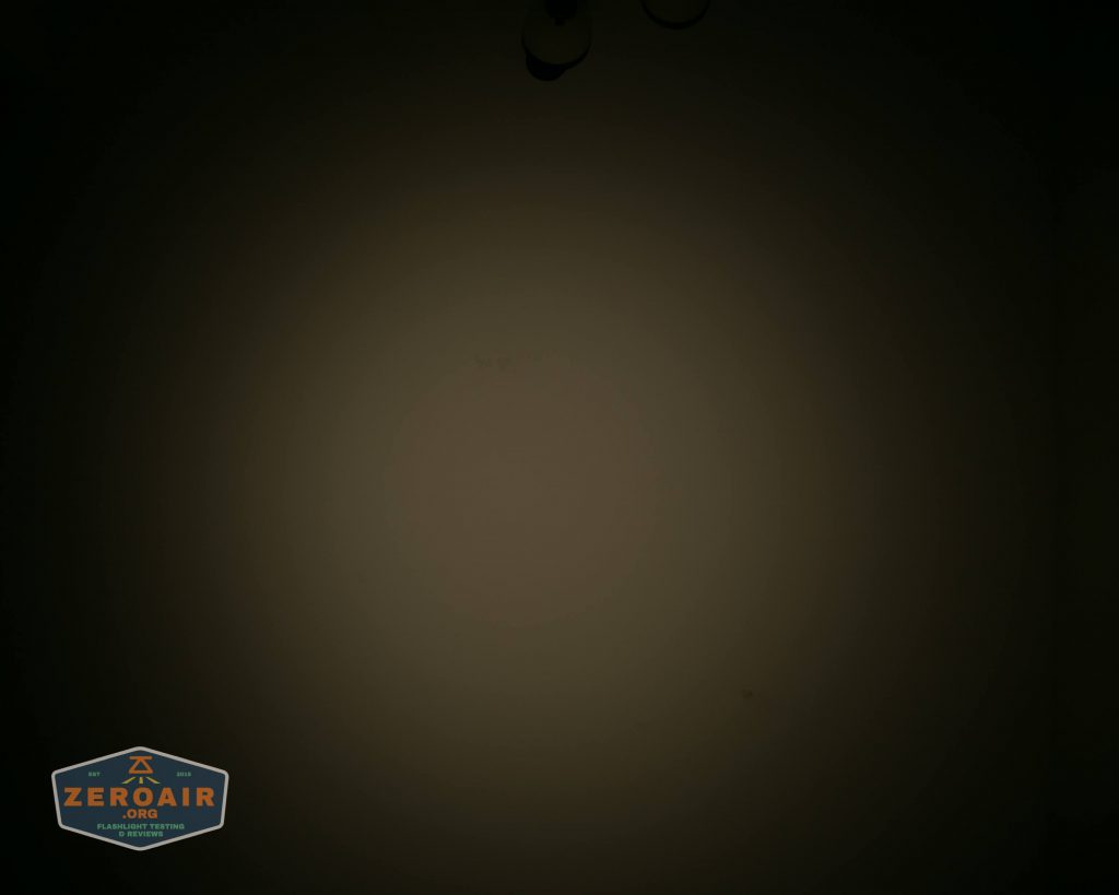 A dim circular light pattern is projected onto a plain, dark surface. The image has a logo in the bottom left corner that reads Zeroair. The overall lighting is low, with the center area slightly brighter.