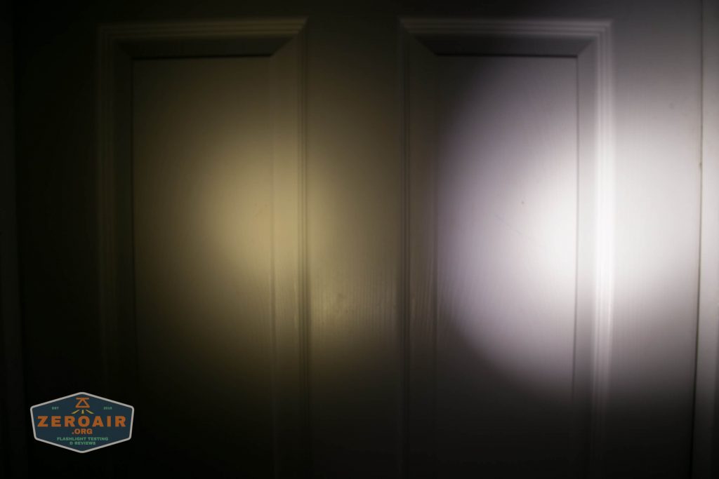 Two flashlight beams are shown on a white door: the left beam is yellowish and diffuse, while the right beam is white and more focused. There is a small logo at the bottom left corner that reads ZeroAir.