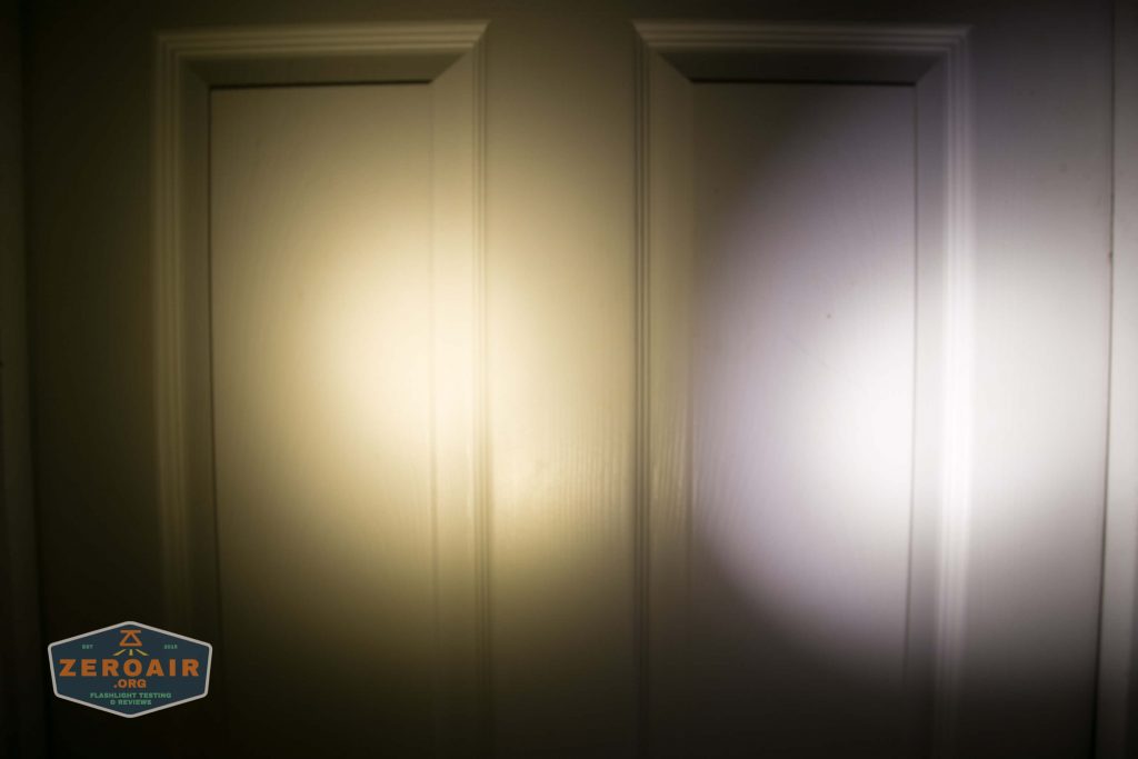 Two overlapping flashlight beams of slightly different colors shine on a white paneled door. There is a ZeroAir logo in the bottom left corner of the image.