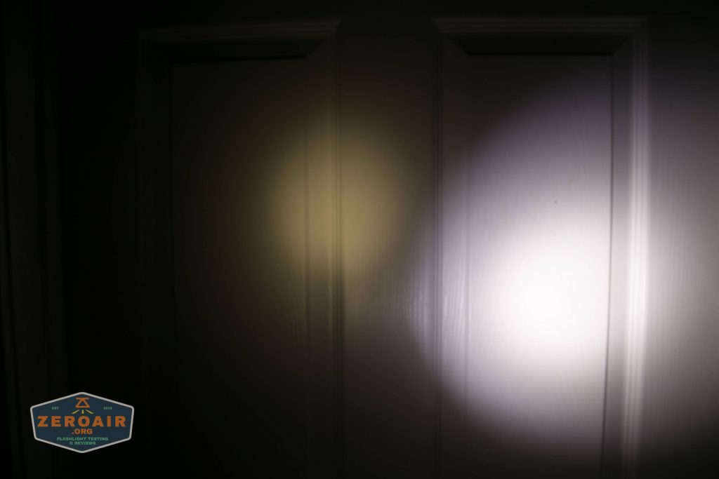 A white door is illuminated by two flashlight beams, one yellowish on the left and one bright white on the right. The door panels and shadows are visible. A logo in the lower left reads ZeroAir.org.