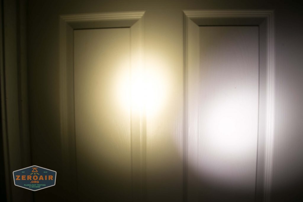 A white door with three vertical panels is illuminated by two overlapping circular beams of light, one warmer and one cooler in color. A small ZeroAir logo is visible in the lower left corner.