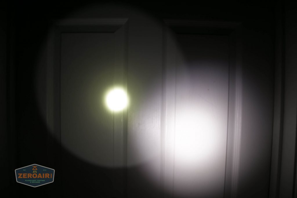 A flashlight beam shines on a closed white door, creating a bright circular spot and a larger, dimmer outer circle; a ZeroAir watermark appears in the lower left corner.