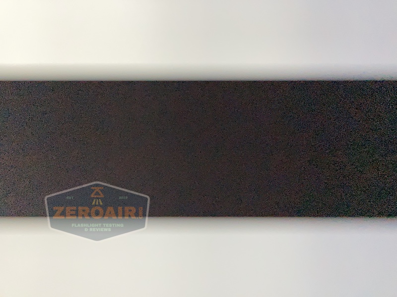 A rectangular, dark foam acoustic panel is mounted on a white wall. A semi-transparent watermark in the lower left corner reads “ZEROAIR FLASHLIGHT TESTING & REVIEWS.”