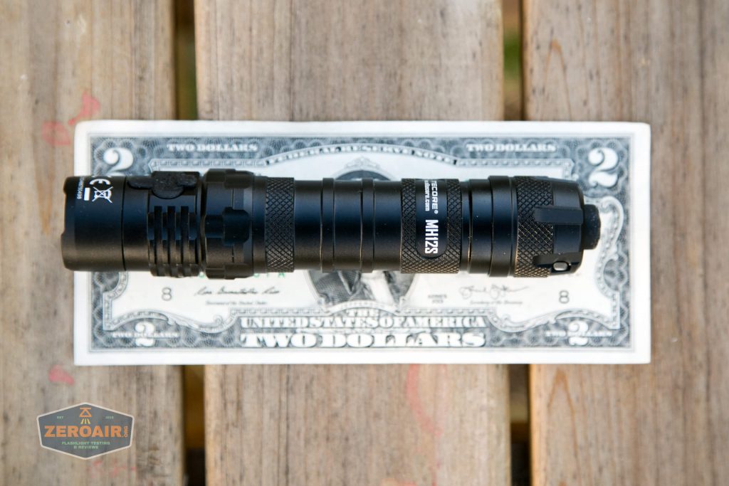 nitecore mh12s tactical flashlight on two dollar bill