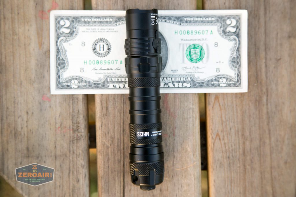 nitecore mh12s tactical flashlight on two dollar bill