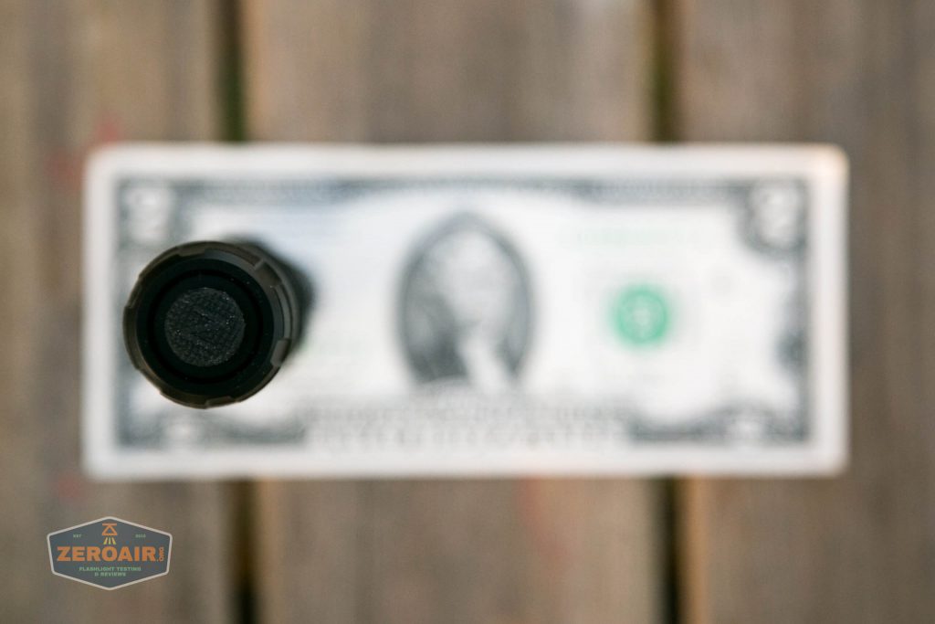 nitecore mh12s tactical flashlight on two dollar bill