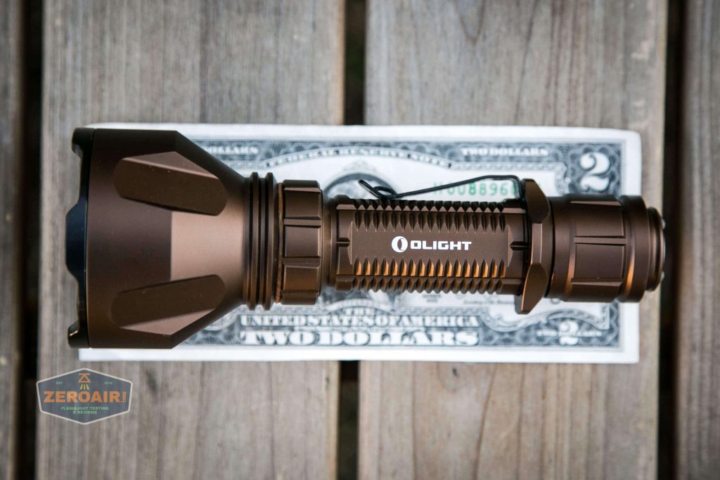 olight warrior x turbo desert tan flashlight on two dollar bill