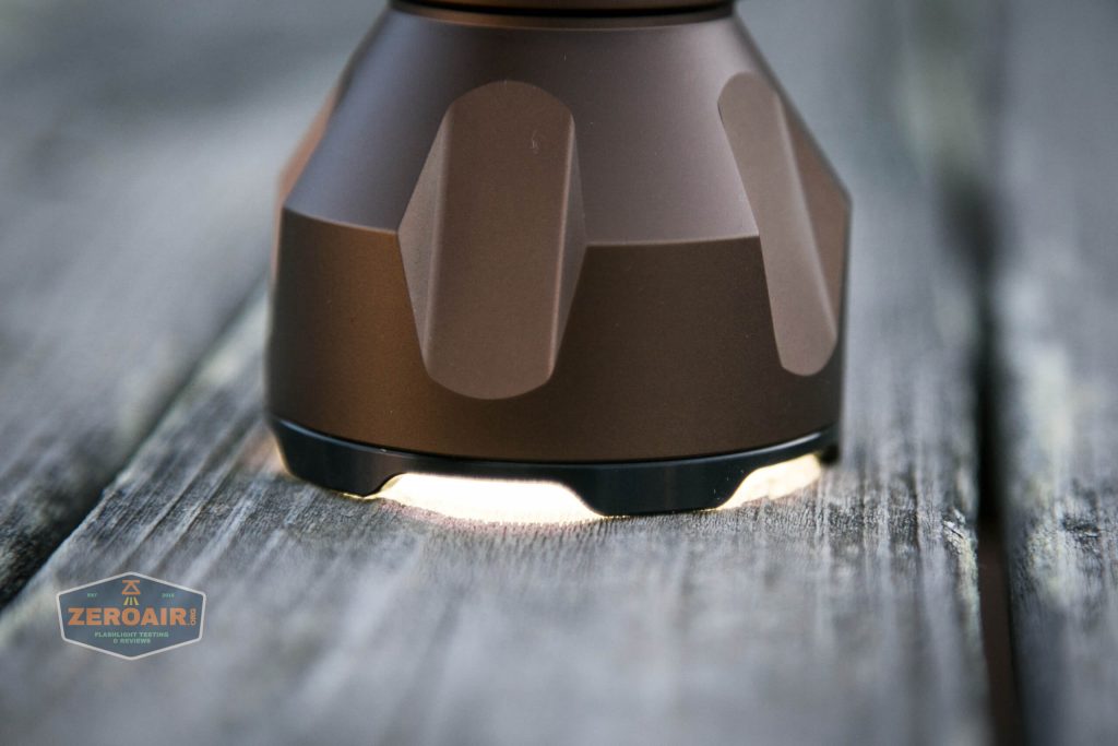 olight warrior x turbo desert tan flashlight headstanding on low