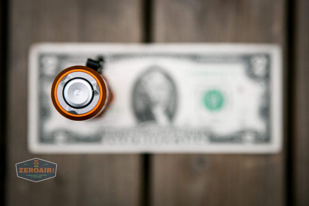 Olight M2R Pro Warrior Orange on two dollar bill