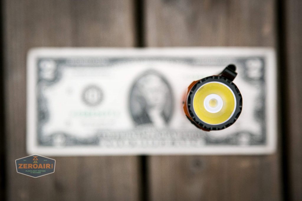 Olight M2R Pro Warrior Orange on two dollar bill