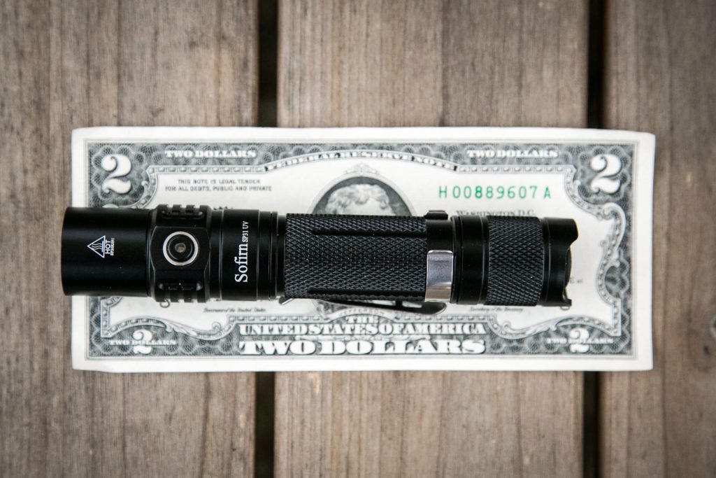 sofirn sp31uv ultraviolet 18650 flashlight on two dollar bill