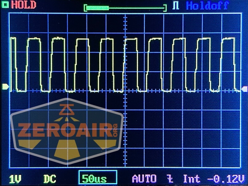 Oscilloscope screen displaying a yellow square waveform signal. The horizontal scale reads 50 microseconds per division, and the vertical scale is 1 volt per division. The ZeroAir.org logo is overlaid on the screen.
